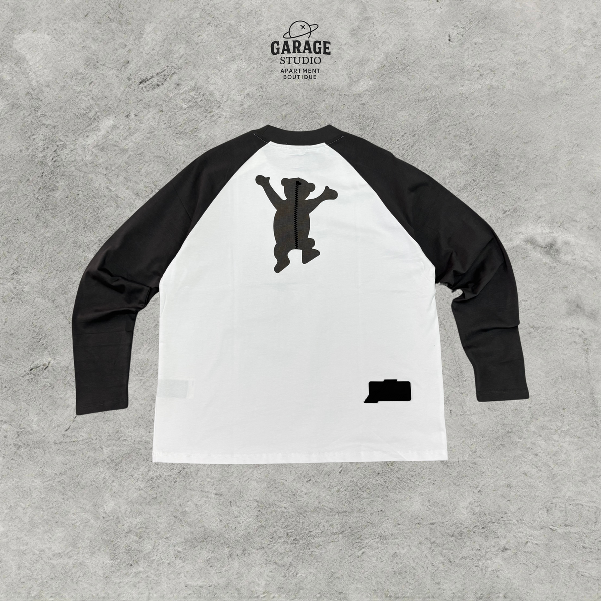 Back of white raglan long-sleeve T-shirt with black sleeves and bear graphic.