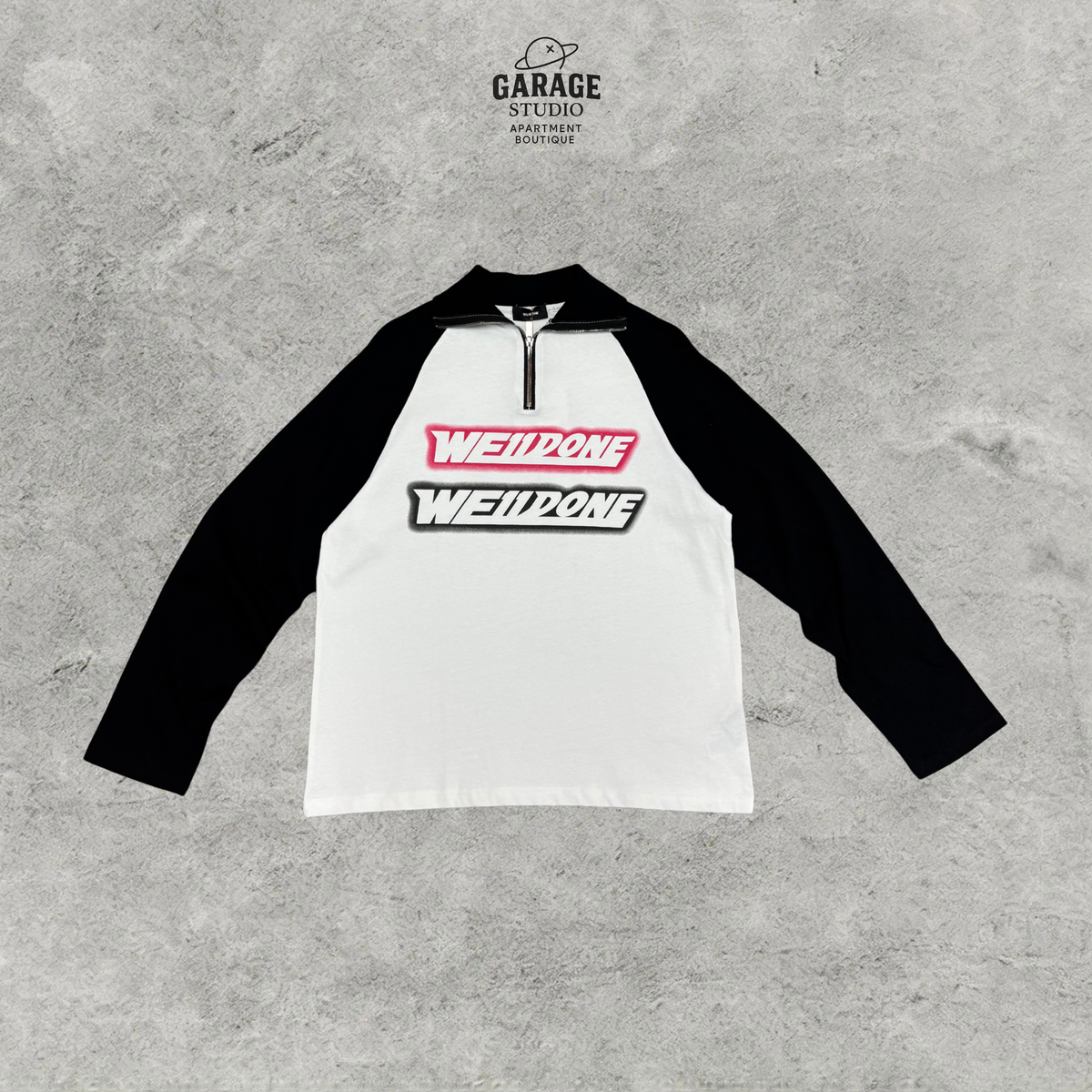 WE11DONE white quarter-zip top with black raglan sleeves and stacked pink and black chest logos.