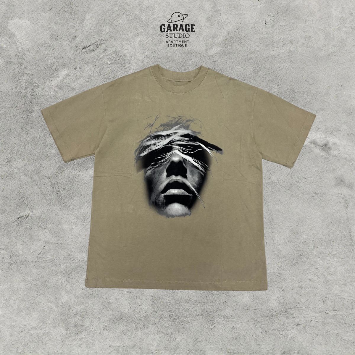 Sand-coloured short-sleeve crew-neck T-shirt with a large black-and-white face graphic on the front.