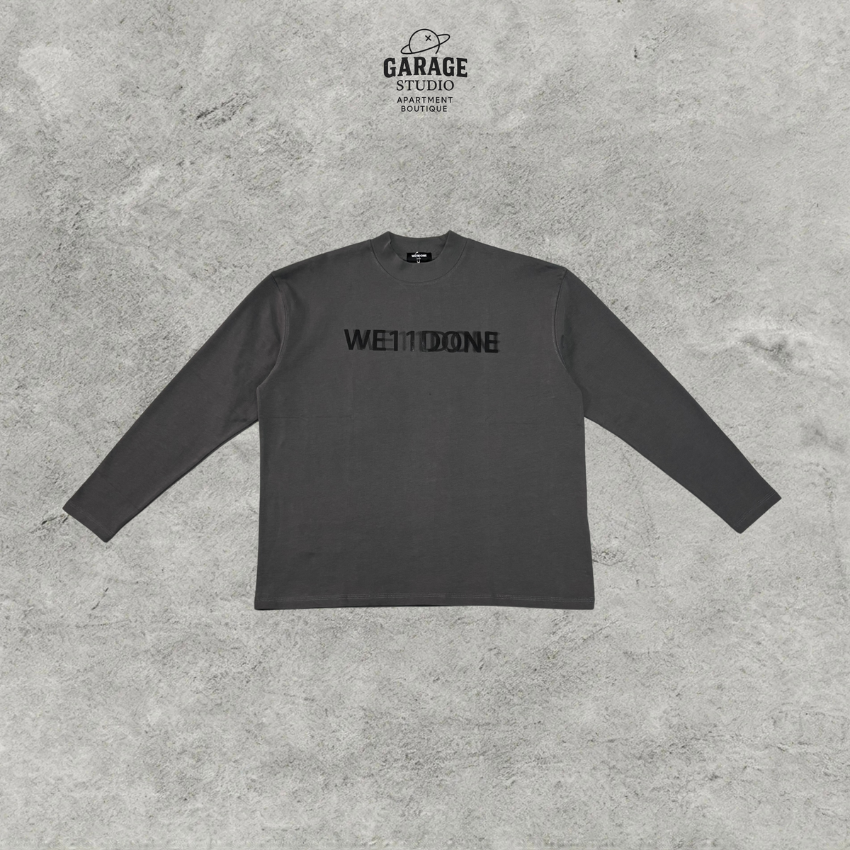 Charcoal WE11DONE long-sleeve crew-neck T-shirt with a tonal black chest logo, shown flat from the front.