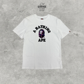 White crew-neck T-shirt with black A BATHING APE lettering and purple camouflage ape-head chest graphic